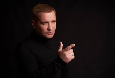 Ciddi adam işaret parmak uzakta arıyorum. Siyah arka plan üzerine izole