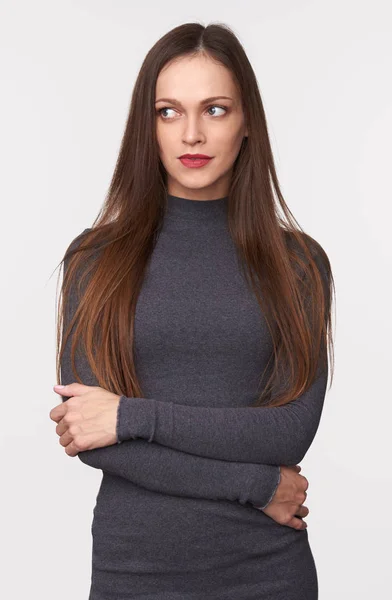 長い茶色の髪を持つ美しい女性はセーターを着ているとよそ見空間にコピーします 灰色のスタジオの背景に分離 — ストック写真