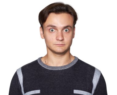 şaşırmış genç adam kameraya bakıyor. Gri studio arka plan üzerinde izole