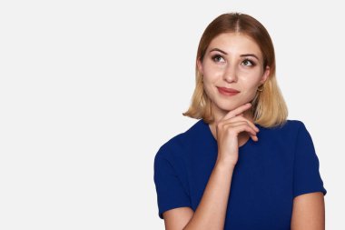 Yukarıya bakıp bir şey hayal gülümseyen kadın. Gri studio arka plan üzerinde izole
