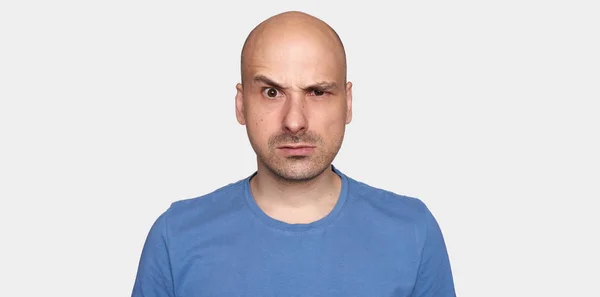 Man Höjde Sina Ögonbryn Arga Skallig Kille Blå Shirt Isolerad — Stockfoto