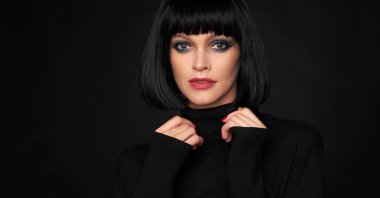 Siyah arka plan üzerinde bir güleryüzlü esmer kadın portresi