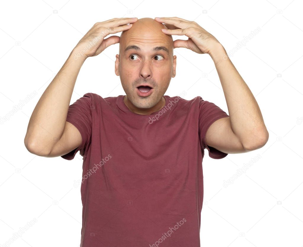 surprised bald man holds his head in hands and looking aside. Isolated