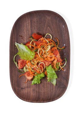 İzole ahşap plaka üzerinde vejetaryen sebze salatası