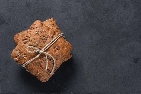 Φέτες ψωμί σικάλεως ολικής άλεσης με σπόρους σε πέτρινη σανίδα — Φωτογραφία Αρχείου