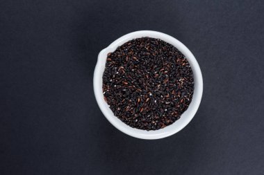 Siyah arka planda bir kasede yaban pirinci. Üst görünüm