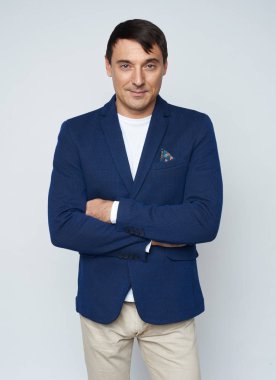 Kolları çapraz yakışıklı adam gülümsüyor. Izole