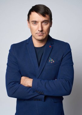 Mavi ceketli ciddi yakışıklı adam kameraya bakıyor. Izole