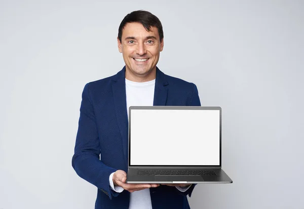 Szczęśliwy przystojny mężczyzna pokazuje pusty ekran laptopa — Zdjęcie stockowe
