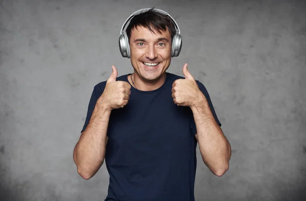 Hombre feliz guapo en los auriculares está escuchando música —  Fotos de Stock