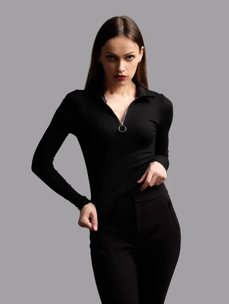 Schönes Mädchen in schwarzer Kleidung posiert isoliert auf grauem Rücken — Stockfoto