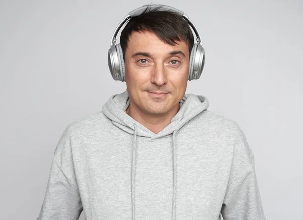 Schöner Mann hört Musik isoliert auf grauem Hintergrund — Stockfoto