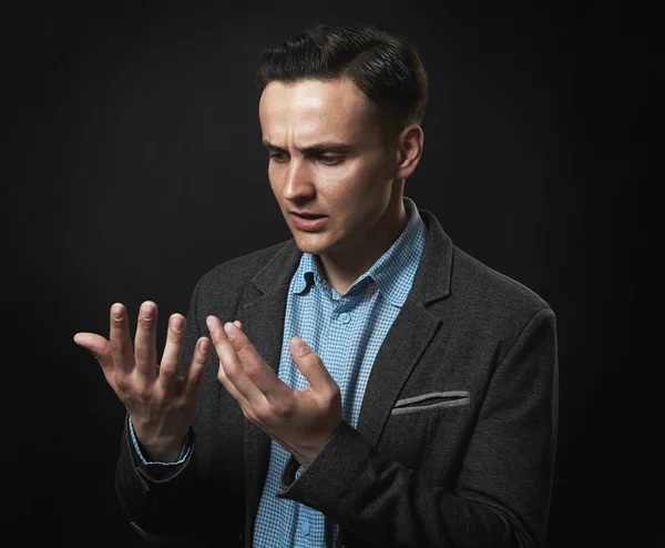 Hombre guapo pensativo está mirando sus manos — Foto de Stock