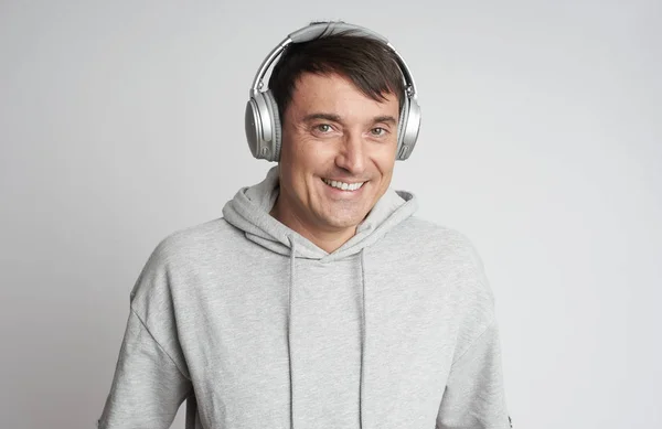 Hombre sonriente escuchando música en auriculares aislados —  Fotos de Stock