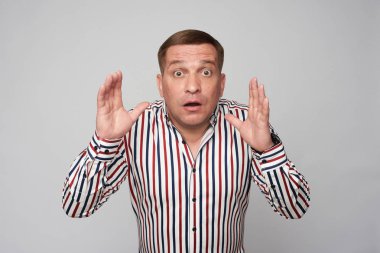 Gri stüdyo duvarında izole şok orta yaşlı adam