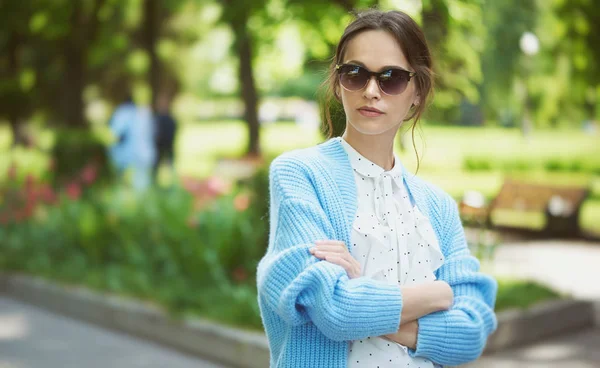Pretty woman in is wearing sunglasses and blue knitted sweater — Stock Photo, Image