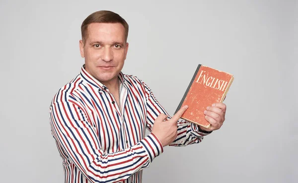 Middle aged man holds an english book — Stock Photo, Image