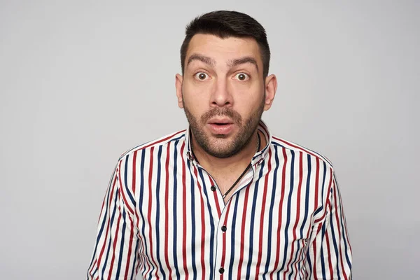 Sorprendido hombre guapo barbudo con camisa a rayas. Aislado — Foto de Stock