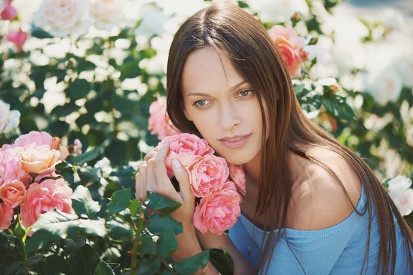 Mooi meisje met rozen bloemen in het stadspark — Stockfoto
