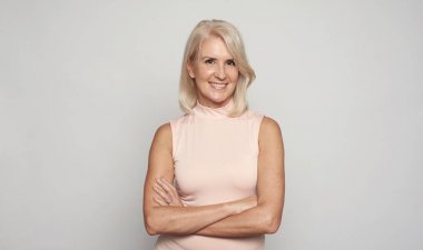 Güzel 50 yıllık bayan elleri katlanmış gülümsüyor. Izole