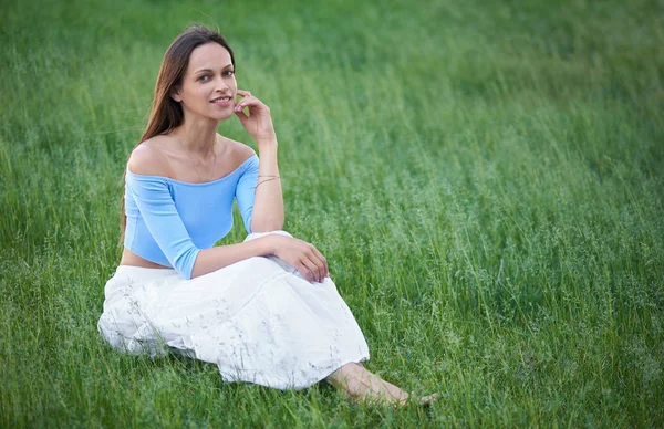 A mulher bonita feliz está sentada numa relva. Verão ao ar livre portra — Fotografia de Stock