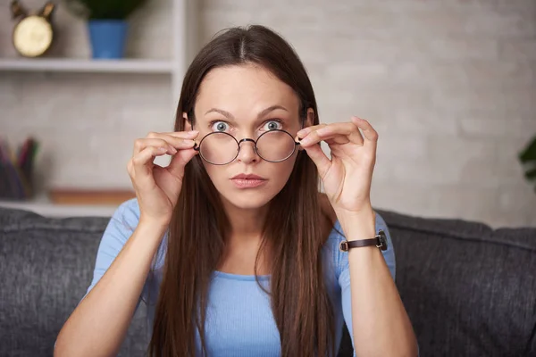 Mujer joven conmocionada está usando gafas redondas — Foto de Stock