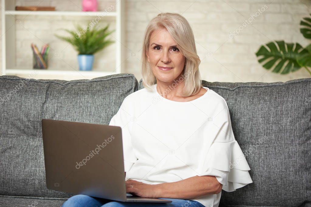 Senior woman at home websurfing on laptop computer
