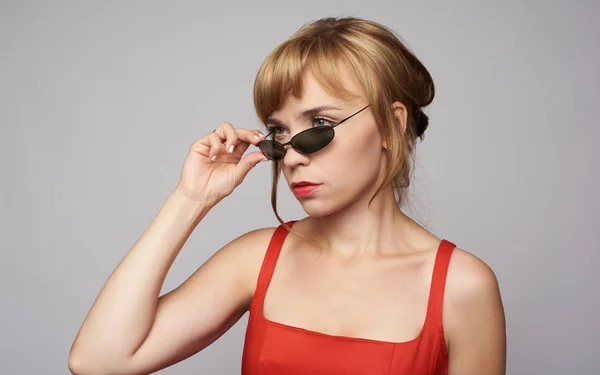 Junge schöne Frau mit rotem Kleid und Sonnenbrille isoliert — Stockfoto