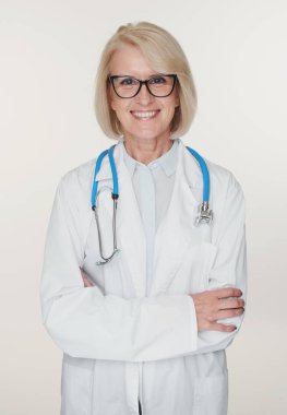 Dost canlısı yaşlı kadın doktor gülümsüyor. Beyaz üzerine izole