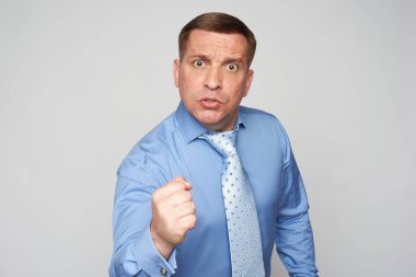 Kızgın işadamı gri arka planda izole