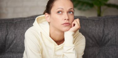 Pensive güzel kadın yukarı bakıyor ve bir şey düşünüyor