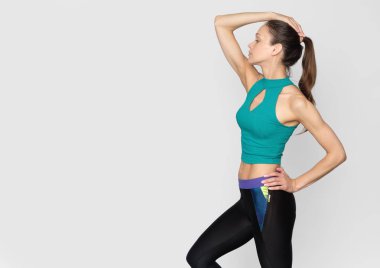 sportif kız gri stüdyo duvar üzerinde izole egzersiz yapıyor