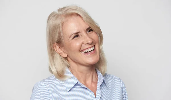 Cheerful senior businesswoman isolated on grey studio wall — Stock Photo, Image