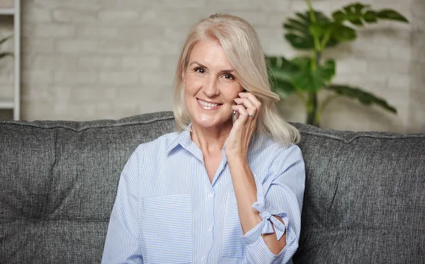 Feliz 50 años mujer está hablando por teléfono en casa —  Fotos de Stock