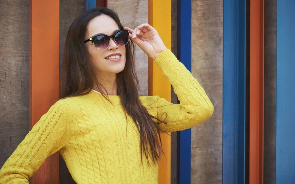 Güneş gözlüklükve sarı süveter giyen mutlu kadın. Dış mekan portresi — Stok fotoğraf