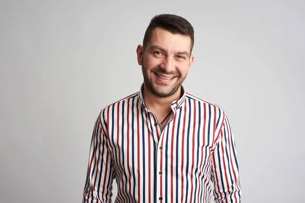 Schöner bärtiger Mann lächelt in einem gestreiften Hemd — Stockfoto