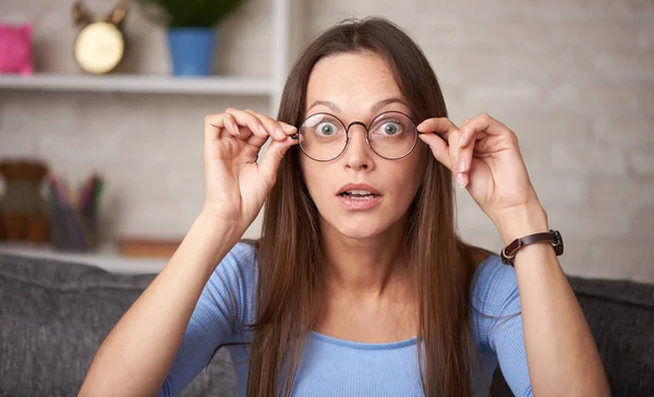 Chockad ung kvinna i glasögon tittar på kamera — Stockfoto