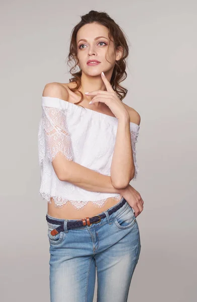 Menina bonita com cabelo encaracolado olhando para cima. Isolado em cinza — Fotografia de Stock