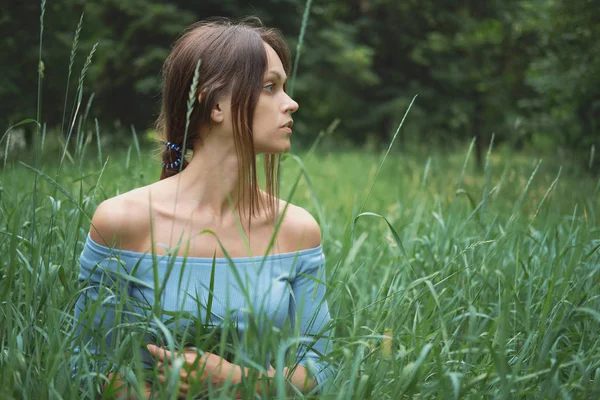 Piękna kobieta w trawie. Na zewnątrz portret ładnej dziewczyny — Zdjęcie stockowe