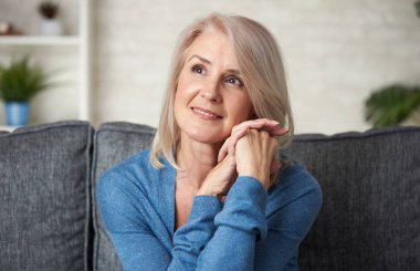 Güzel 50 yaşında kadın evde kanepede rahatlatıcı