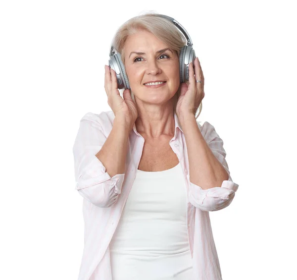 美しい50歳の女性がヘッドフォンで音楽を聴いている — ストック写真