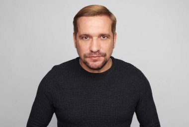 Sakallı adam stüdyo resmi. Gri stüdyo arka planında izole edilmiş.