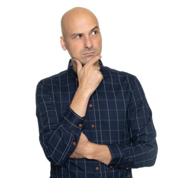 Çenesinde eli olan düşünceli kel adam yalnız başına başka yere bakıyor.