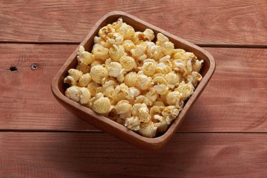 Tahta masadaki kasede patlamış mısır. Üst görünüm