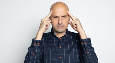 Ciddi, kel bir adam düşünüyor.