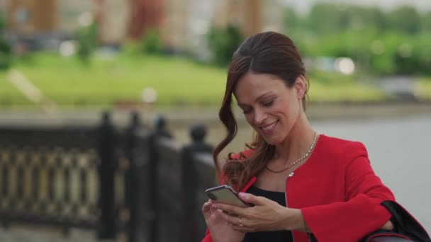 かなりファッショナブルな女性が街の通りにスマートフォンを使用しています — ストック動画