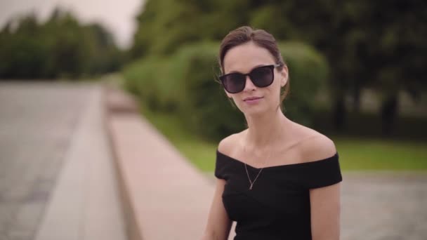 Mujer Negocios Está Usando Vestido Negro Gafas Sol Parque — Vídeos de Stock