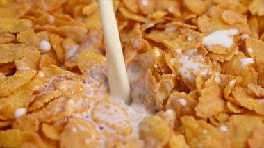 Mısır gevreğinin içine süt dökerek.