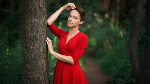 Krásná Mladá Žena Červených Šatech Ubytována Stromu Lese Venkovní Portrét — Stock fotografie