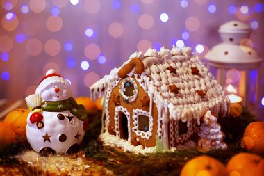 Zencefilli ev ve parlak ışıkları Noel çelenk şenlikli bir zemin üzerine kardan adam. Neşeli Noel ve yeni yıl arka plan